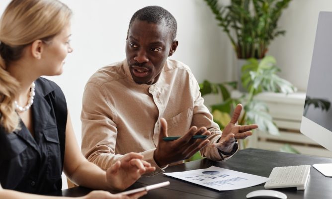 A male and female coworker talking to each other