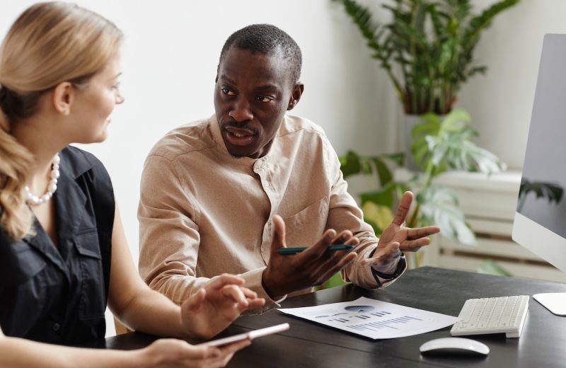 A male and female coworker talking to each other