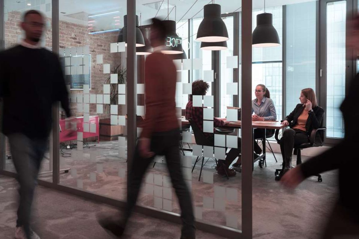 Coworkers walking past a conference room