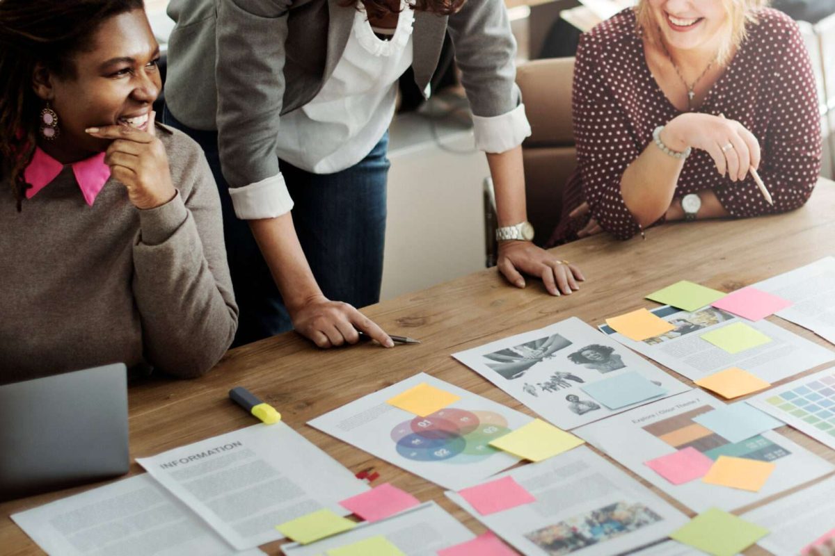 A group of people looking over papers and talking to each other