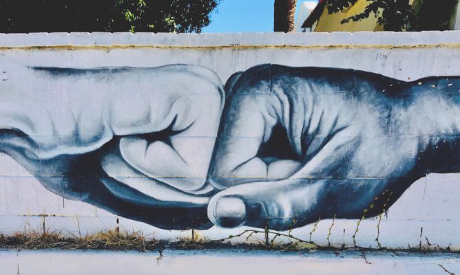 a wall mural of two hands fist bumping