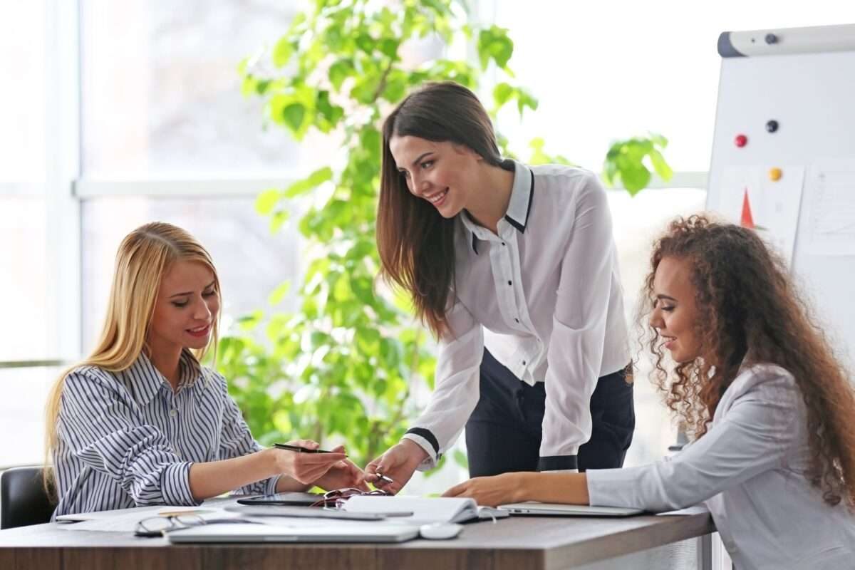 A woman helping two colleagues