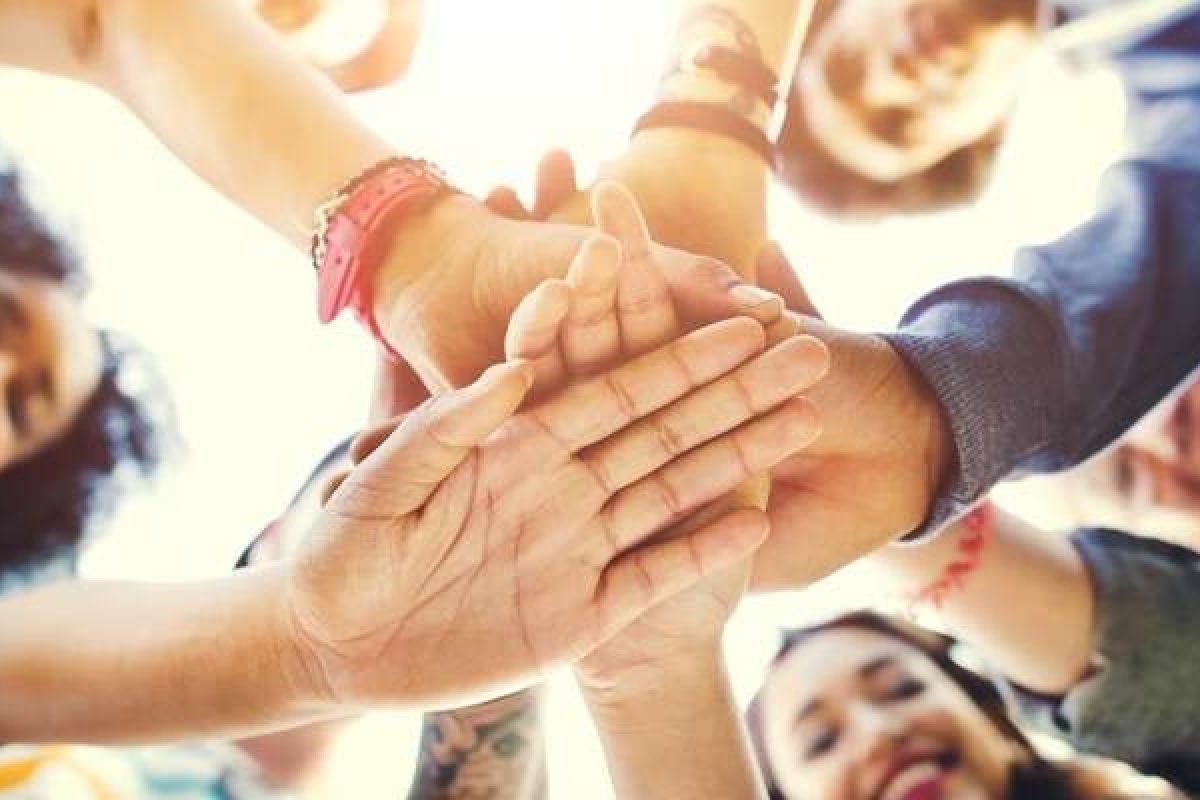 A diverse team putting their hands together in a circle
