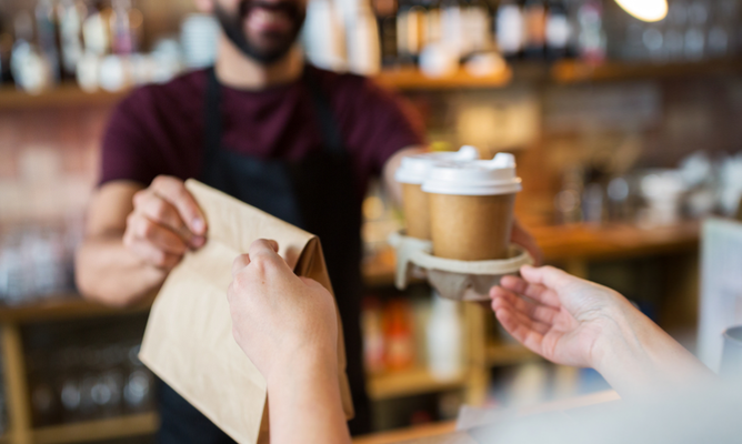 A person getting their takeout order at a cafe