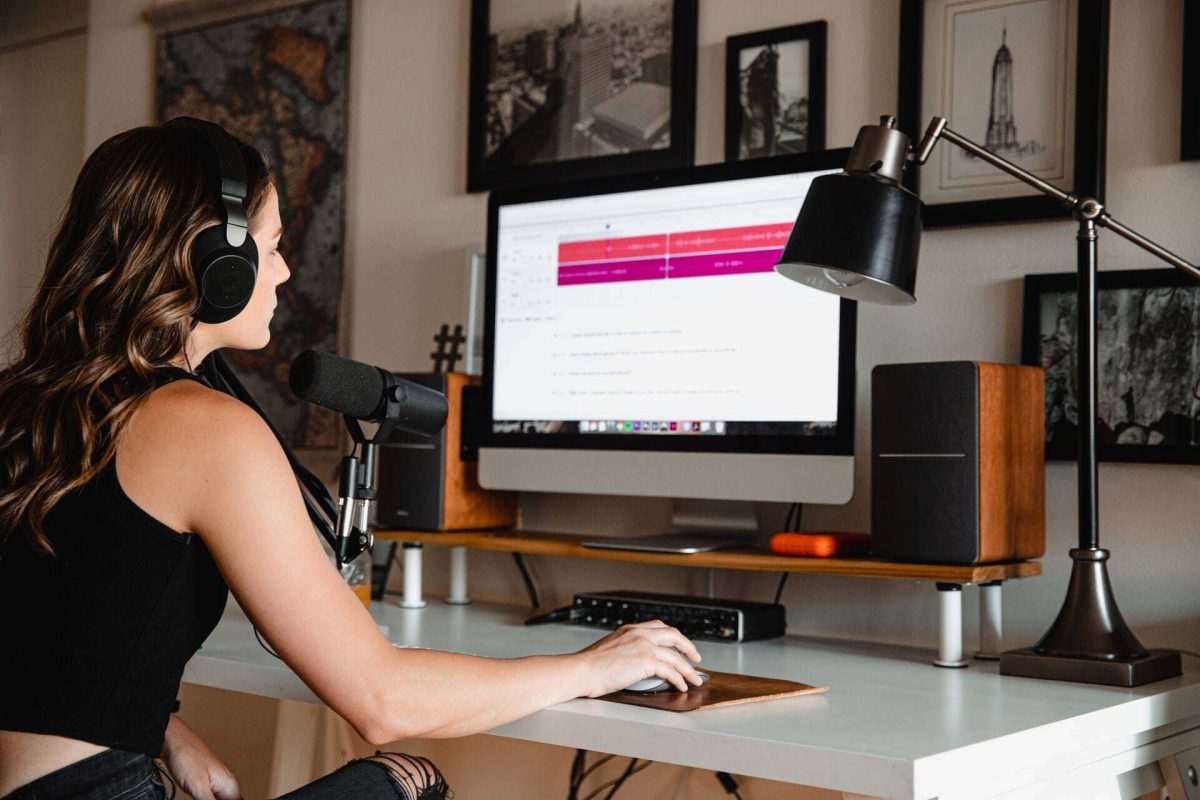 Woman wearing headphones while working on her desktop computer
