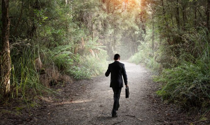 A man in a suit walking in the woods
