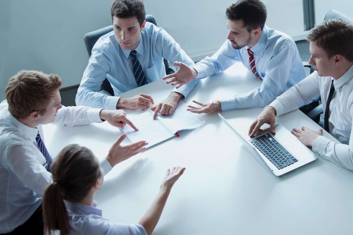 Members of a team sitting around a table talking