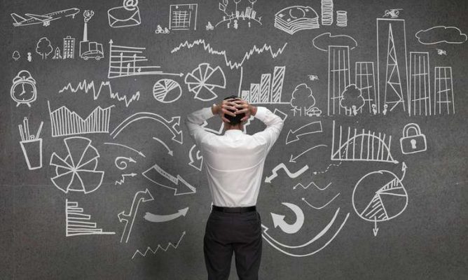 A man looking at a chalkboard with many options