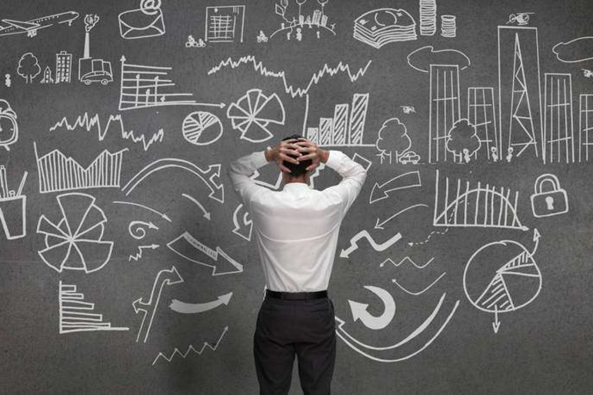 A man looking at a chalkboard with many options